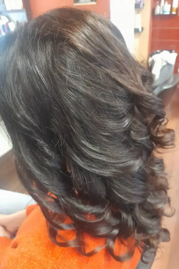 Melena oscura con rizos amplios y volumen
